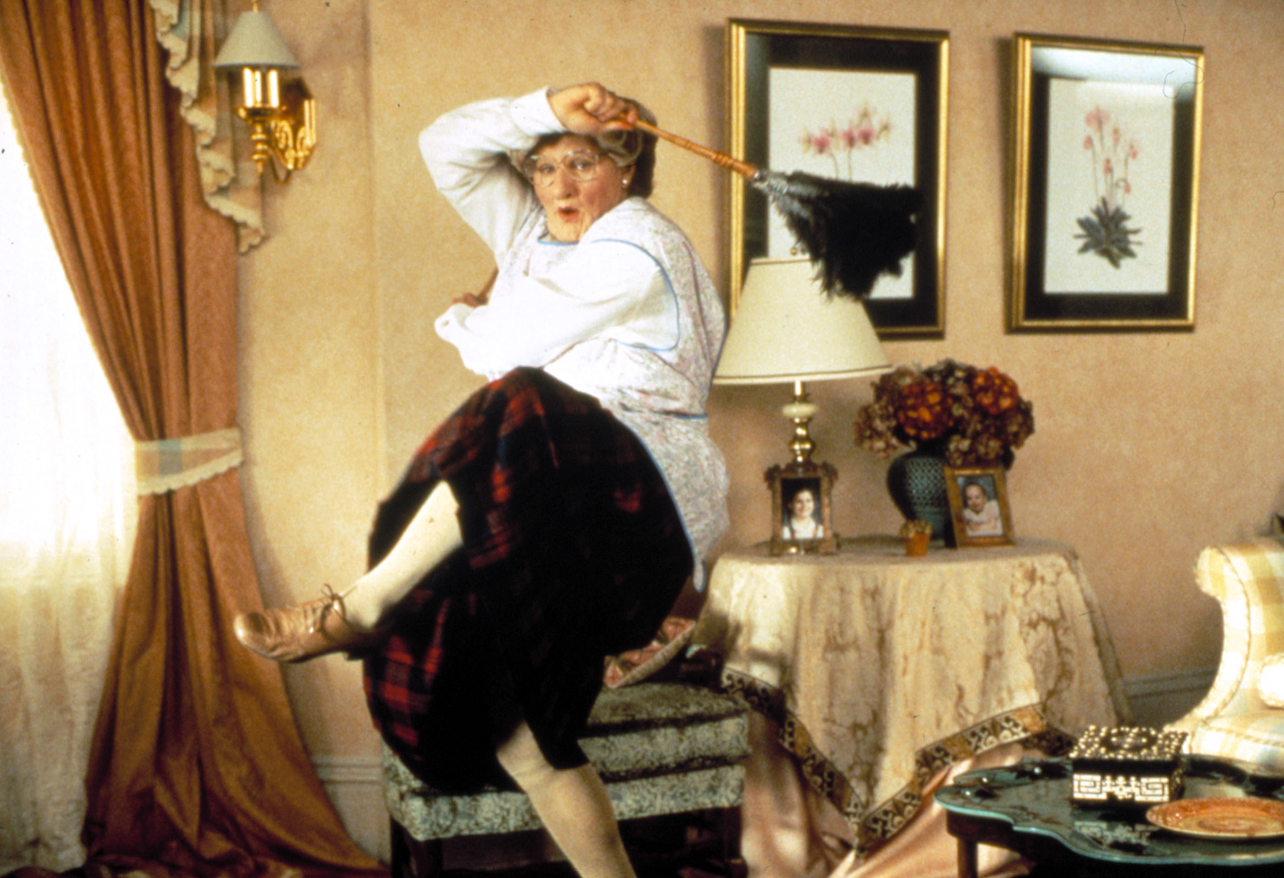 Robin Williams dressed as Mrs. Doubtfire dances in a living room
