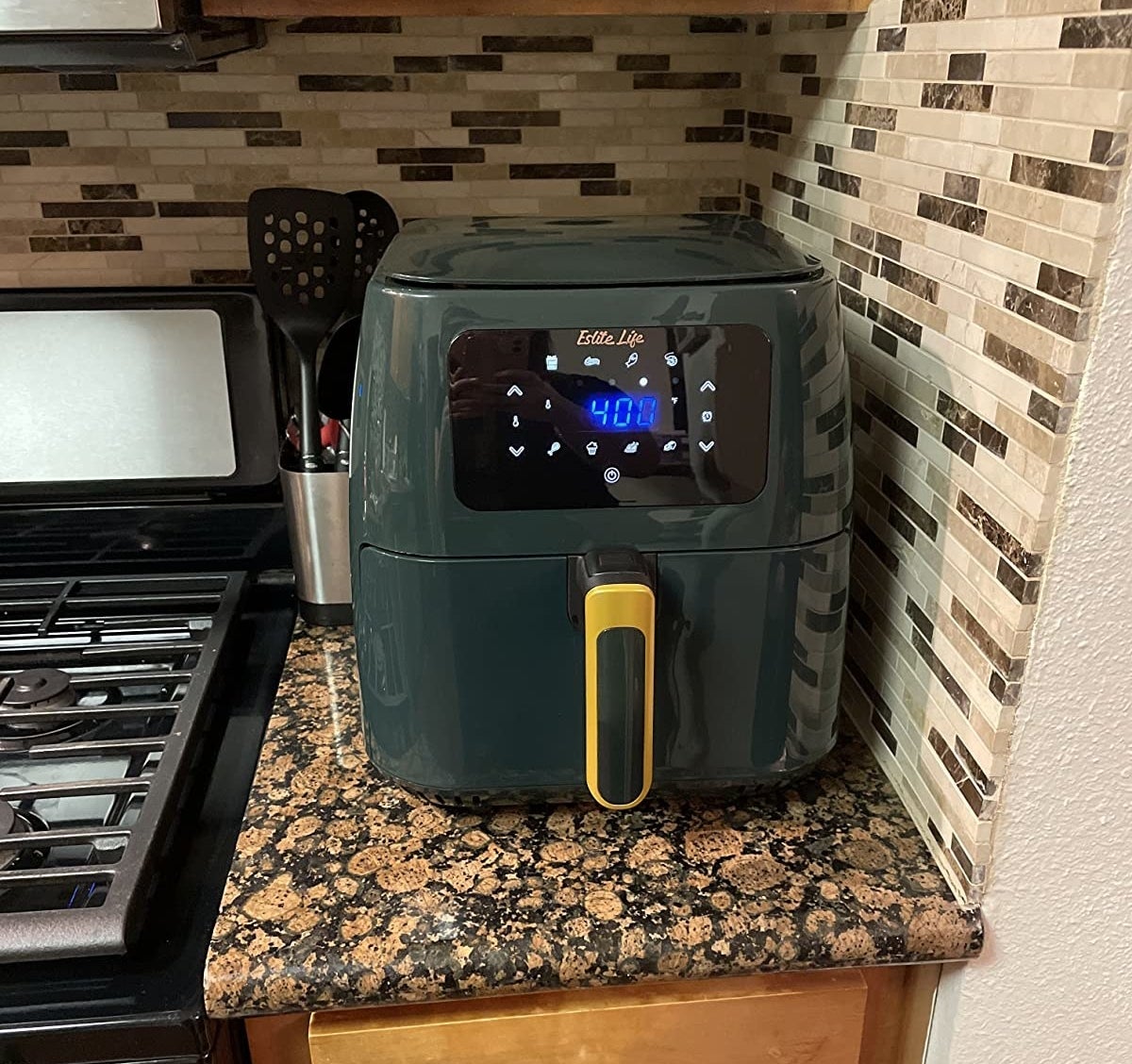 Reviewer photo of a dark green air fryer with a yellow handle