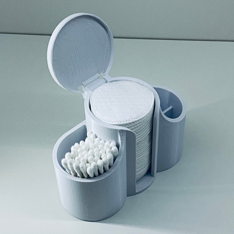 blue gray holder with two open compartments, one with a lid, and one divided compartment, with the center holding cotton pads and one of the sides holding cotton swabs
