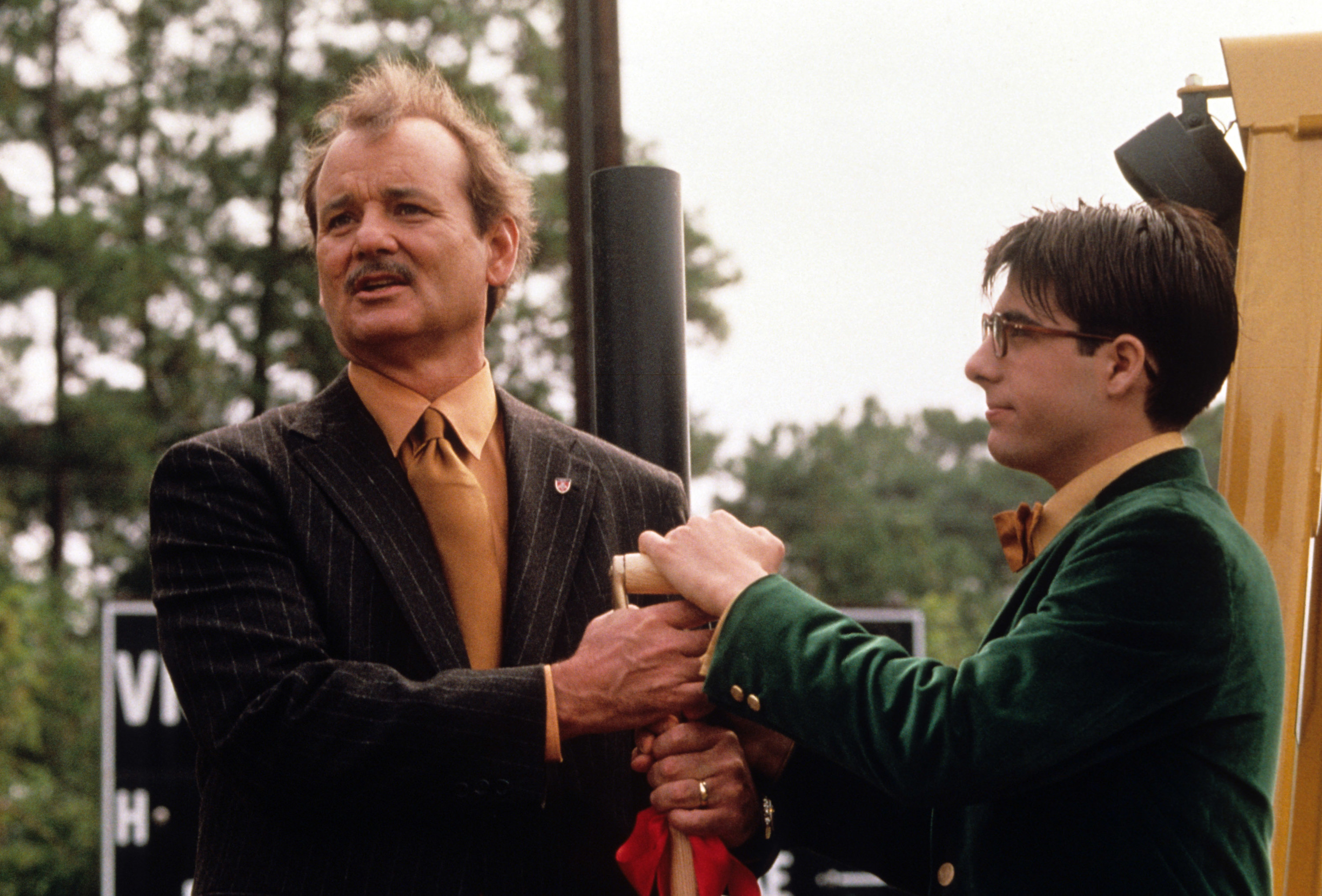 Bill Murray and Jason Schwartzman hold the handle of a shovel together
