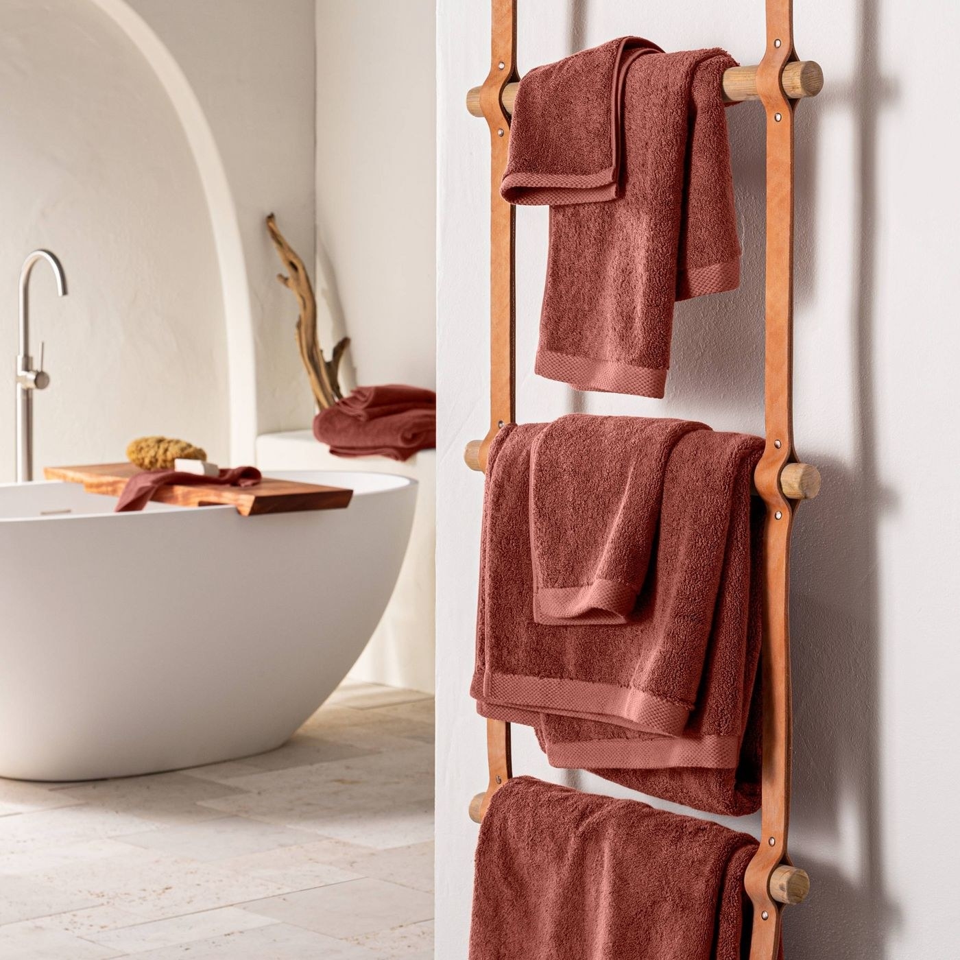 towels of different sizes hung next to a bathtub