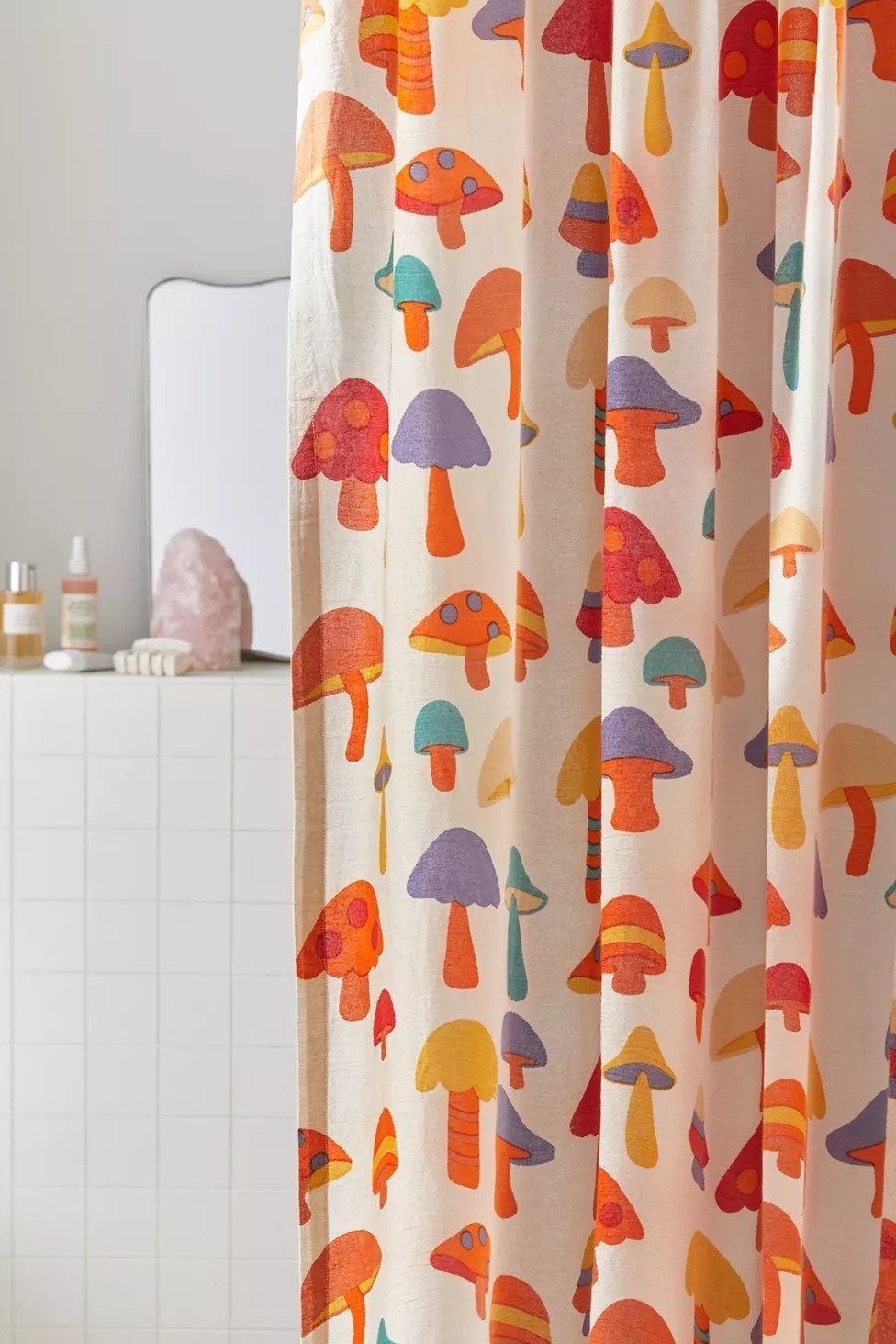 multi-colored mushroom pattern on a shower curtain in a white tile bathroom