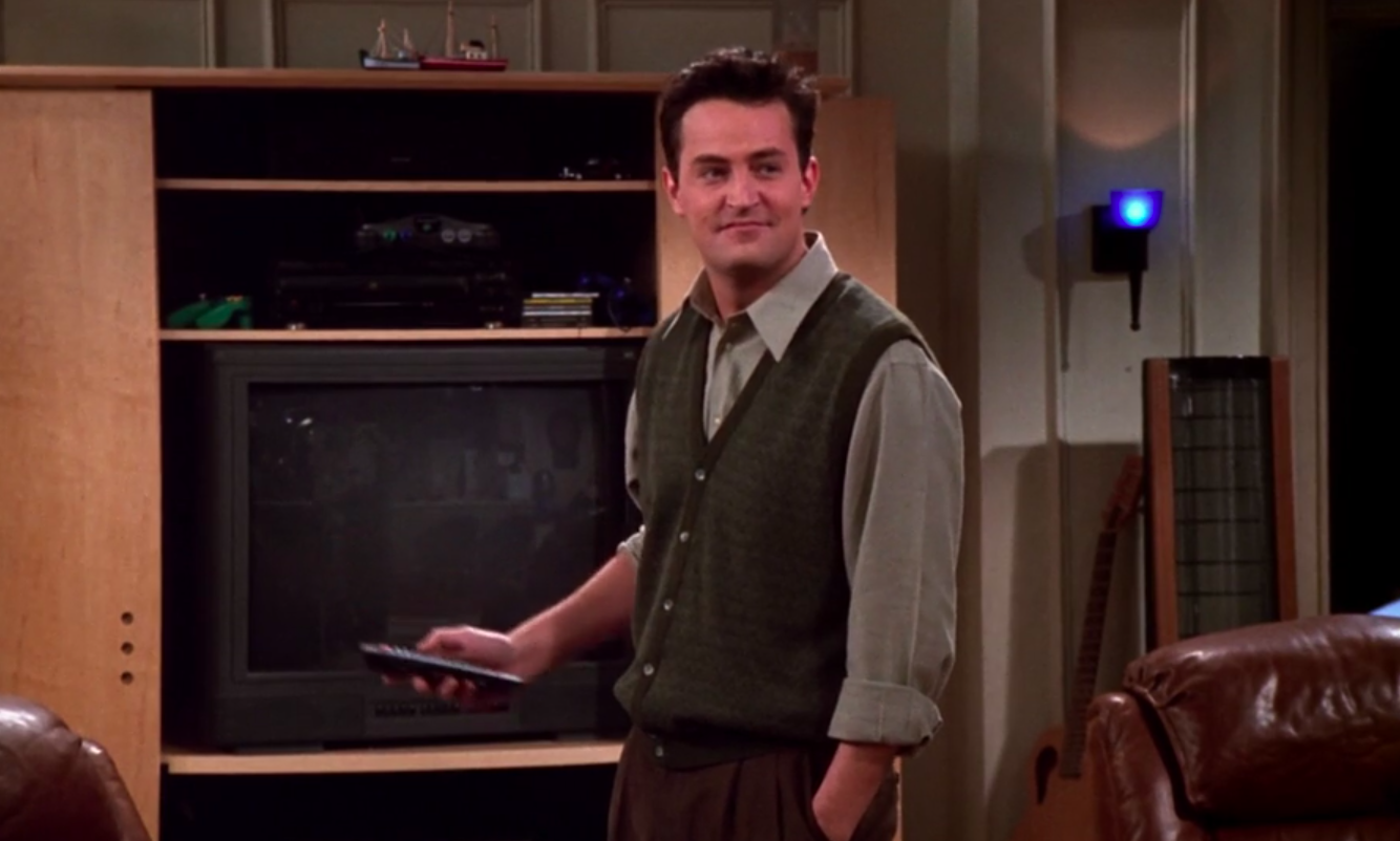 Chandler wearing shoes, pants, a long-sleeved shirt, and a sweater-vest