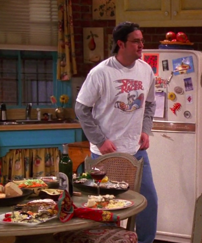 Chandler wearing sneakers, jeans, a long-sleeved shirt, a Speed Racer T-shirt, and a backward hat