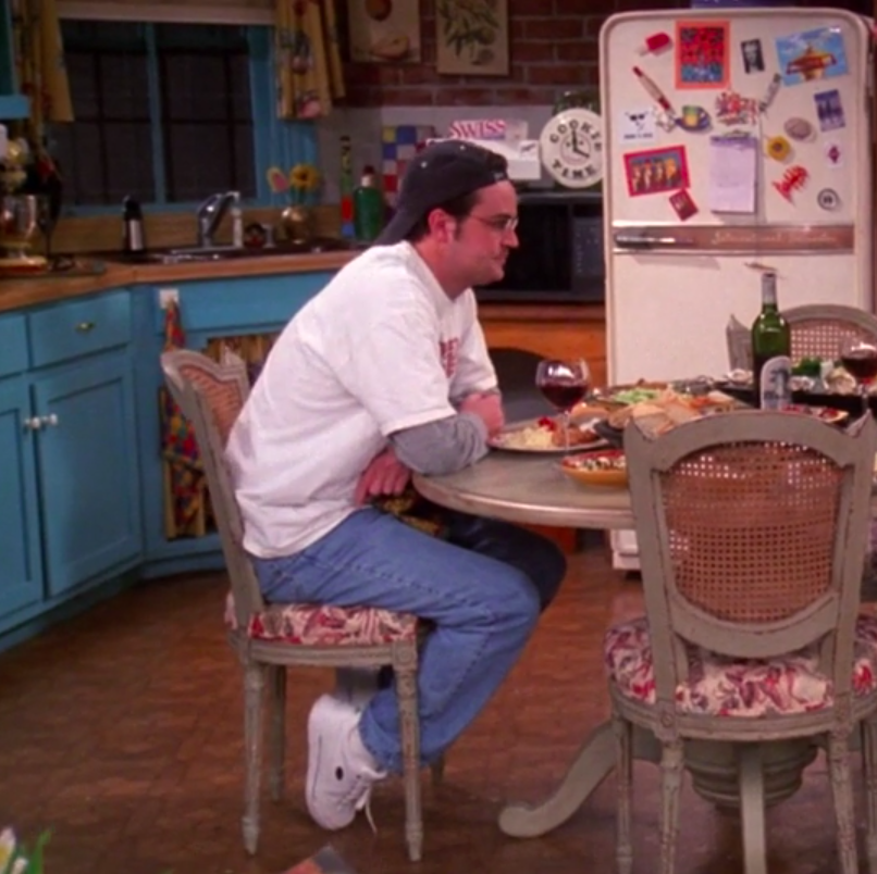 Chandler wearing sneakers, jeans, a long-sleeved shirt, a Speed Racer T-shirt, and a backward hat