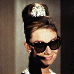 Holly lowering her sunglasses and smiling in Breakfast at Tiffany&#x27;s
