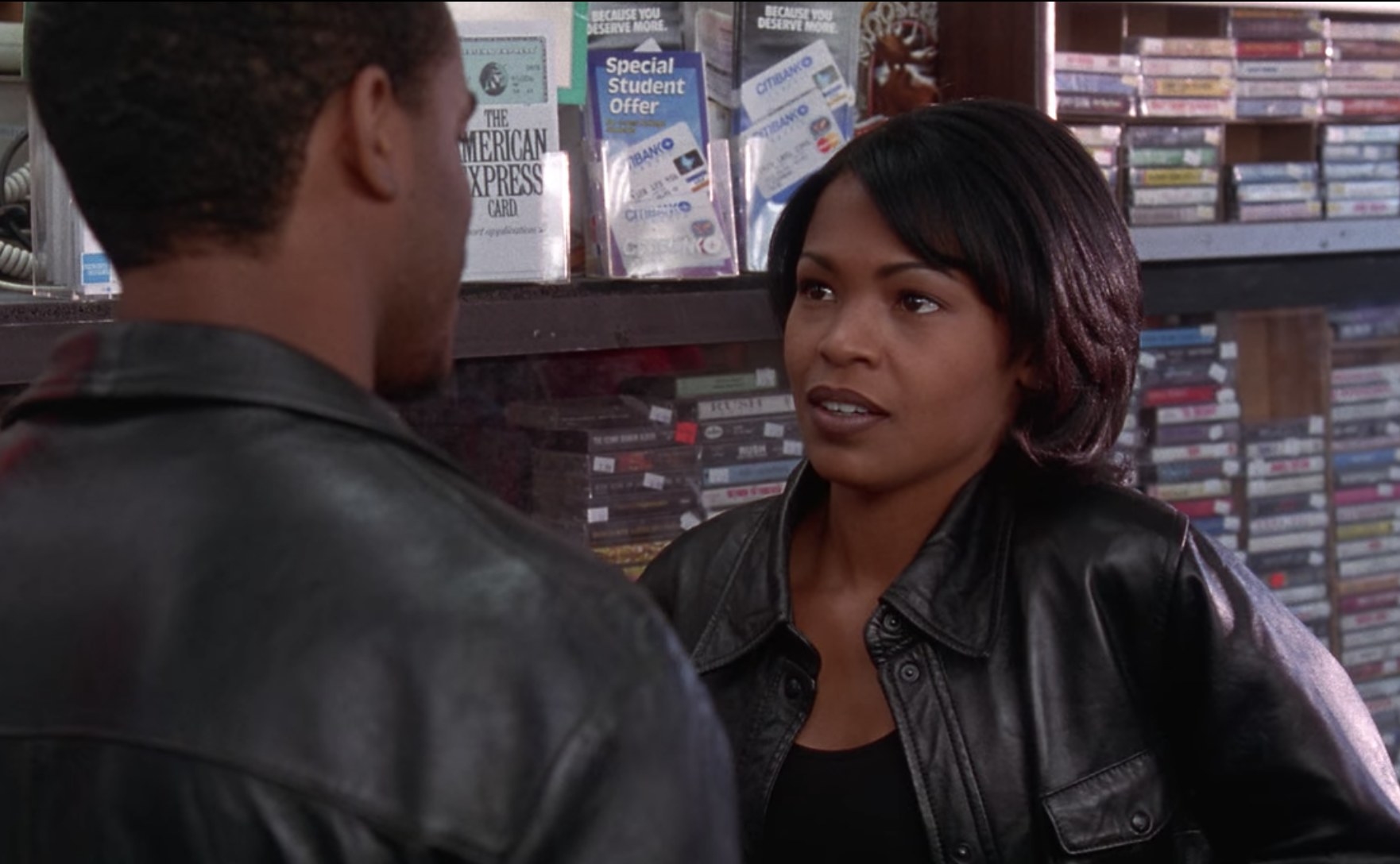 Actress Nia Long looks with uncertainty at a man whose back is facing the camera.