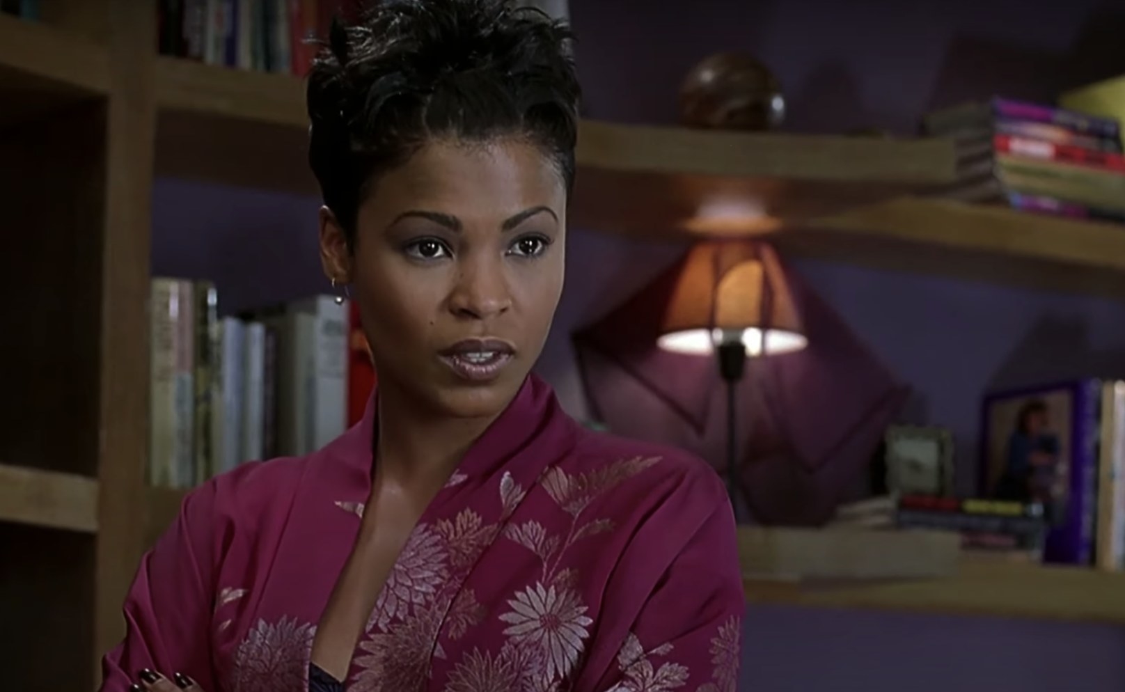 Nia Long wears a pink robe and annoyedly looks offscreen at someone.