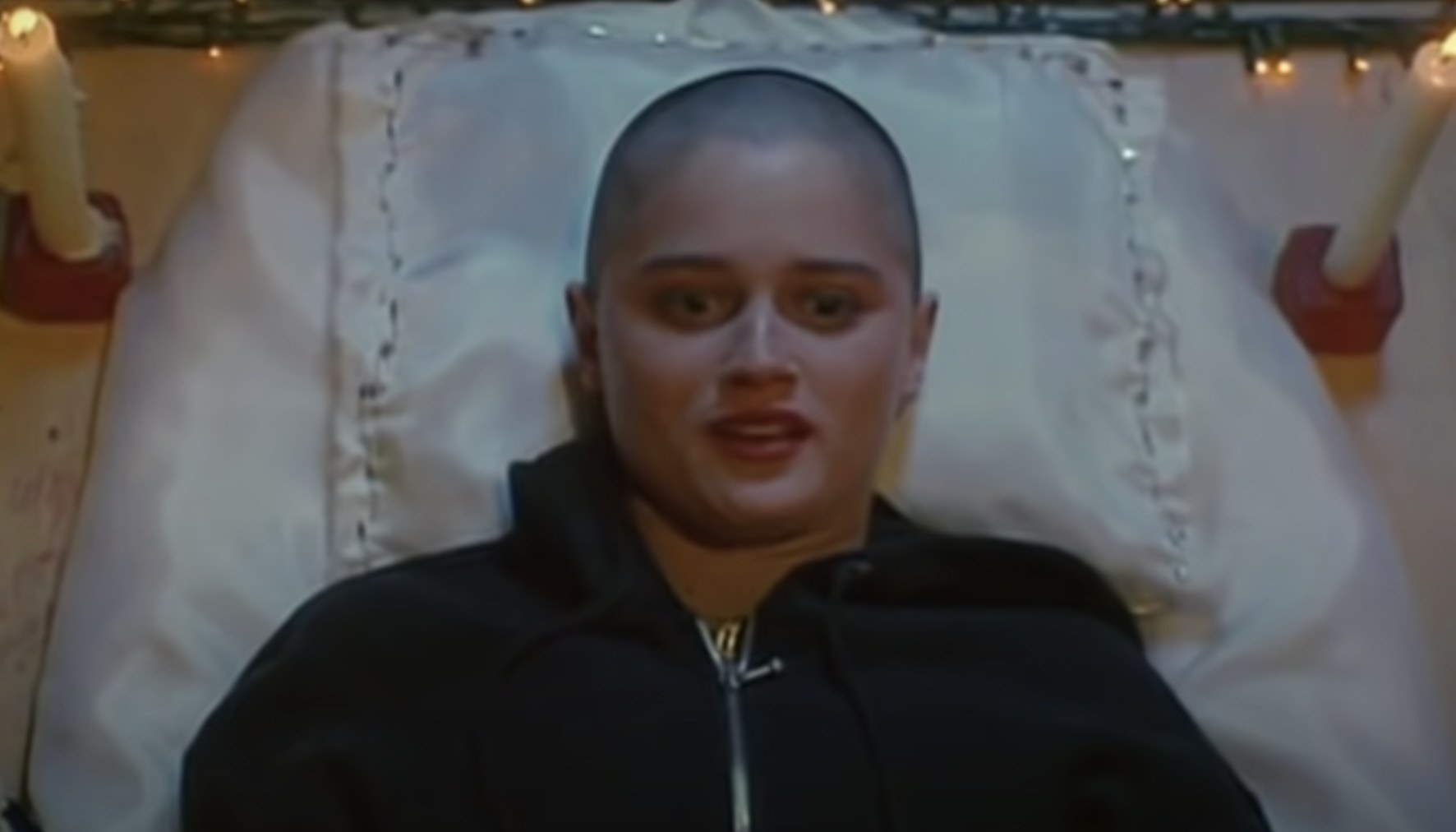 Robin Tunney&#x27;s head is completely shaved and she wears a black zip up hoodie while laying her head on a pillow.