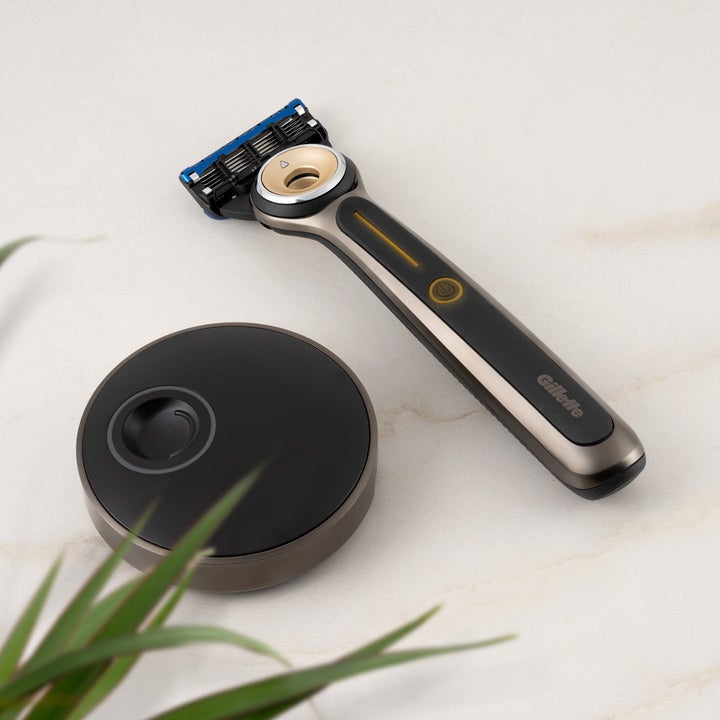 black Heated Razor by GilletteLabs next to sleek charging pad