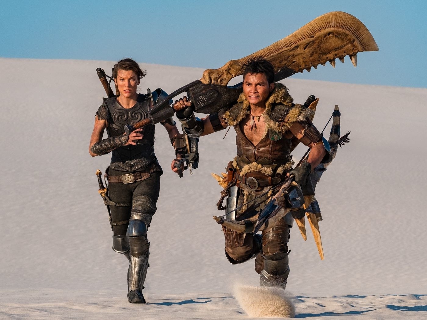 milla jovovich as artemis and tony jaa as the hunter run through the desert
