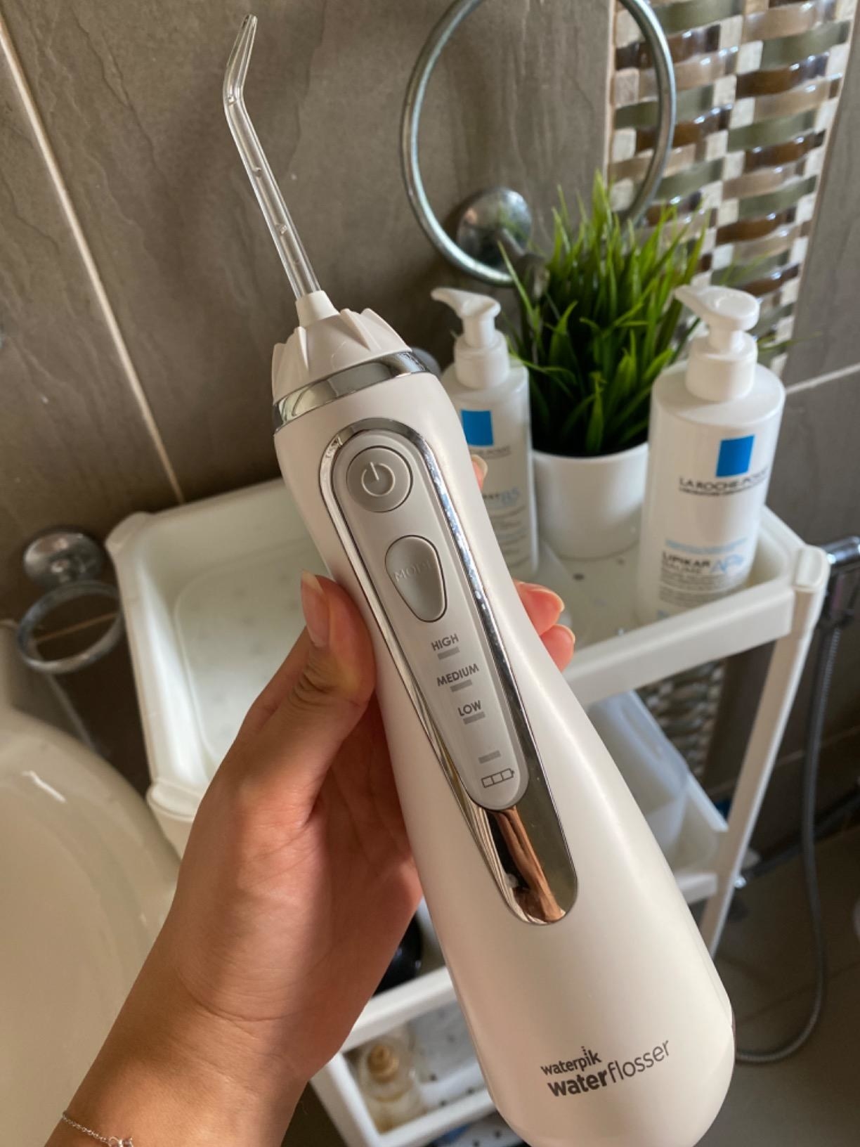 a reviewer holding the white flosser