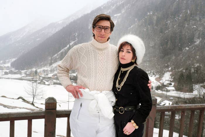Stars Lady Gaga and Adam Driver stand outside in front of a snowy mountain