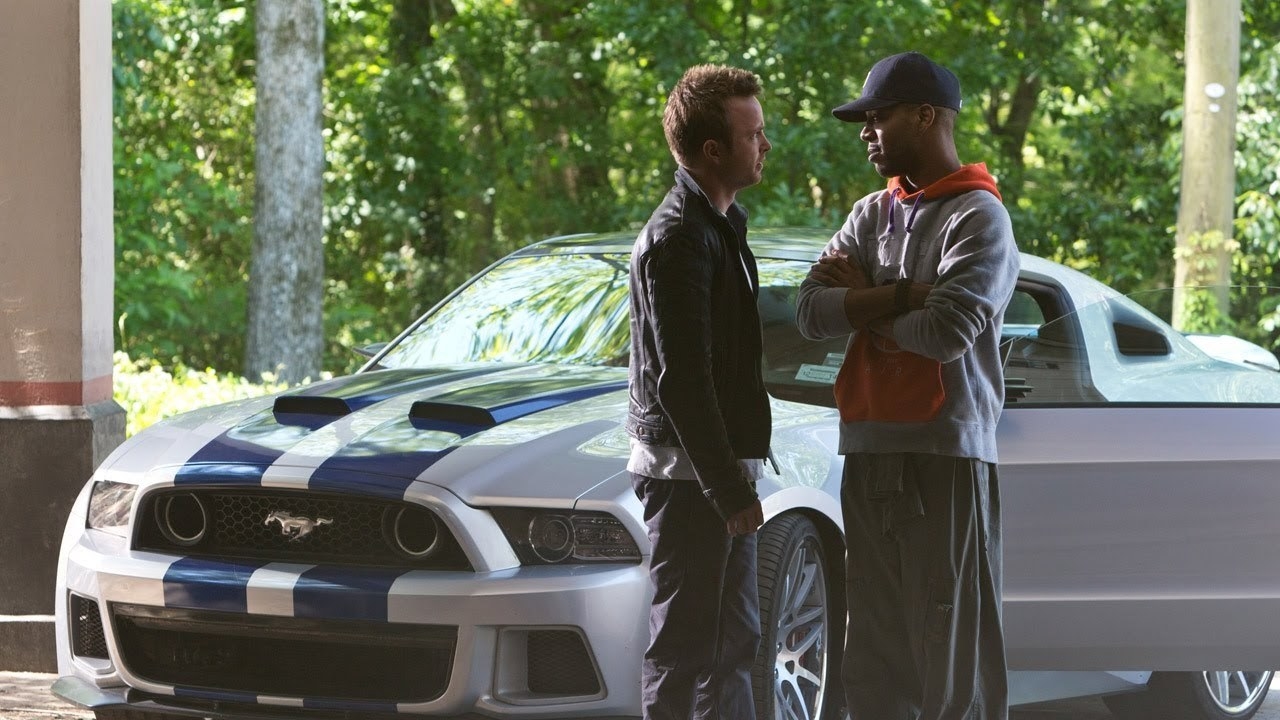 aaron paul as tobey marshall standing next to his car