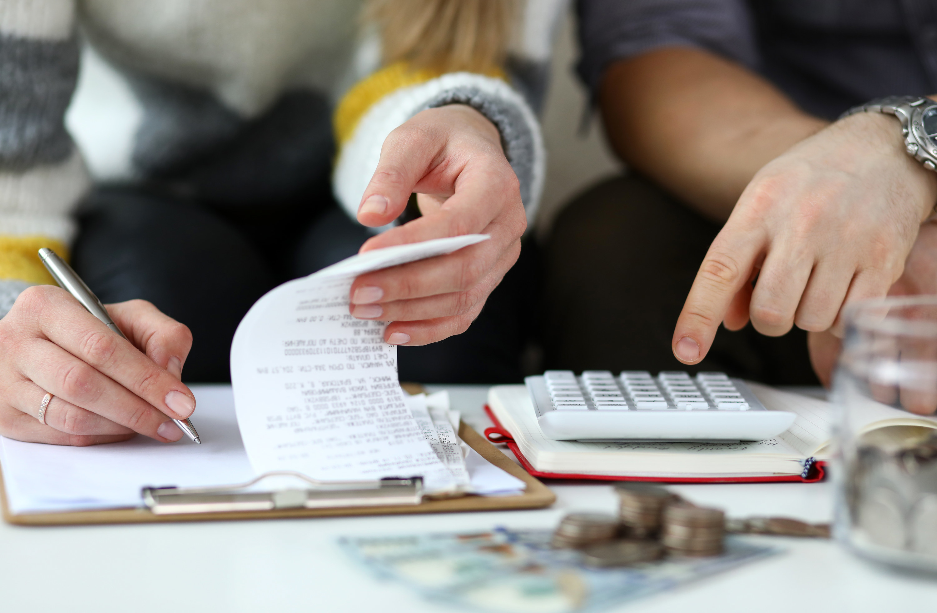 Couple going through receipts with a calculator