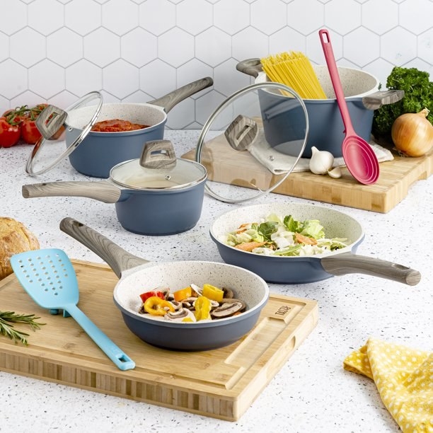 The cookware set on a kitchen counter with food.