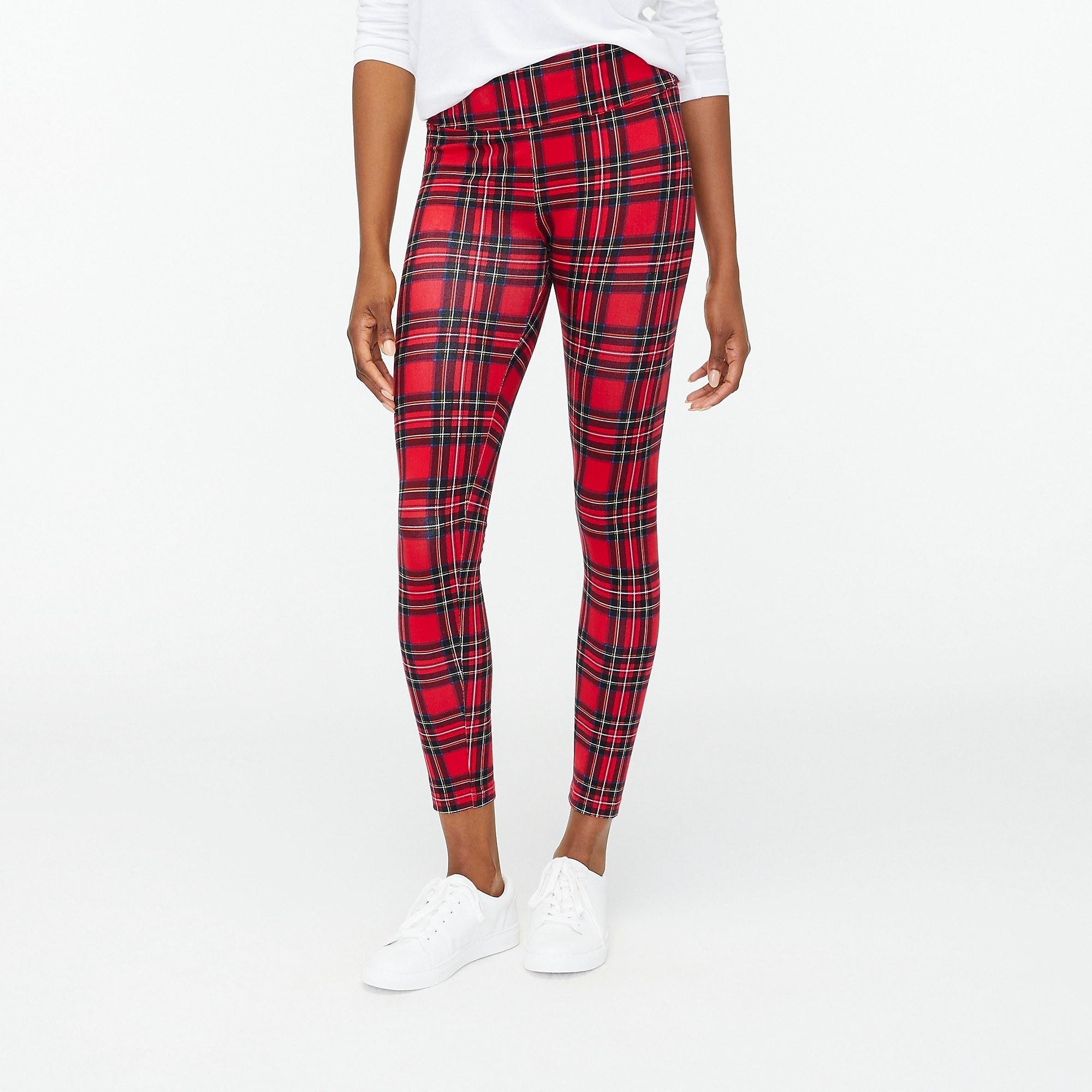 Model wearing red, green and white plaid leggings with white shirt and shoes