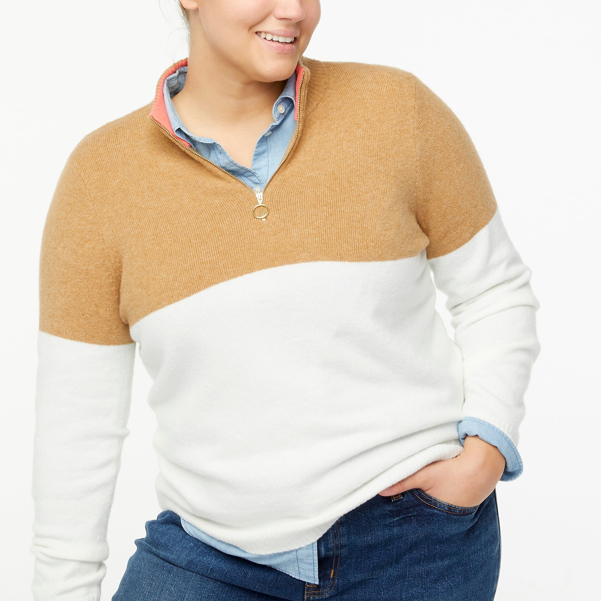 Model wearing tan and white quarter zip with blue shirt and jeans