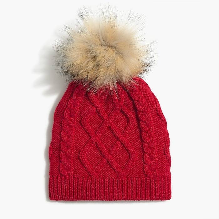 A red hat with light brown pompom on top