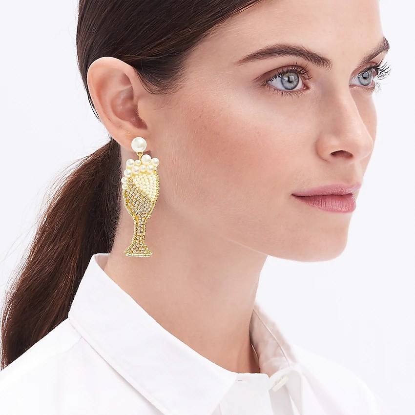 Model wearing gold and pearl champagne earrings with white shirt