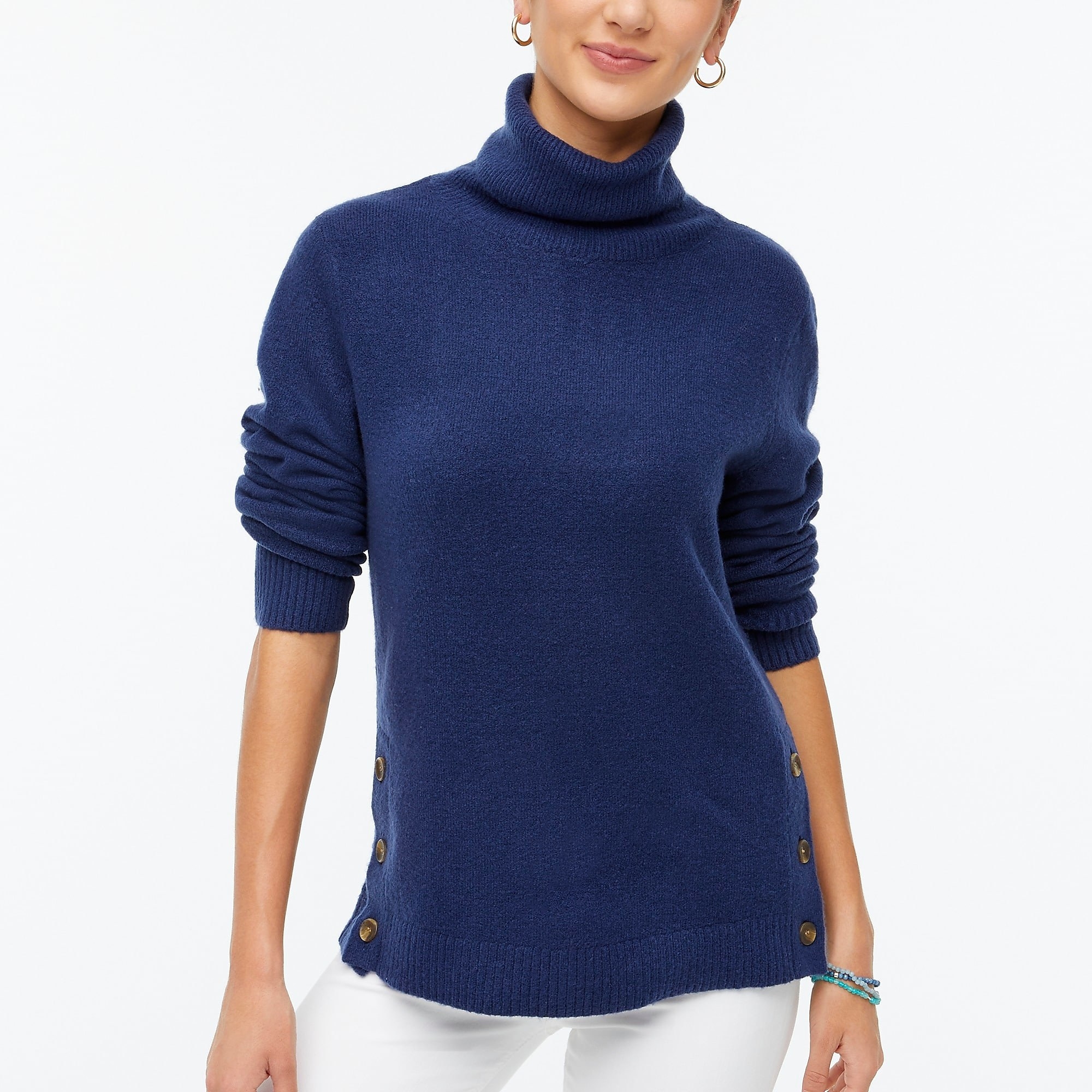 Model wearing a blue turtleneck with button detailing