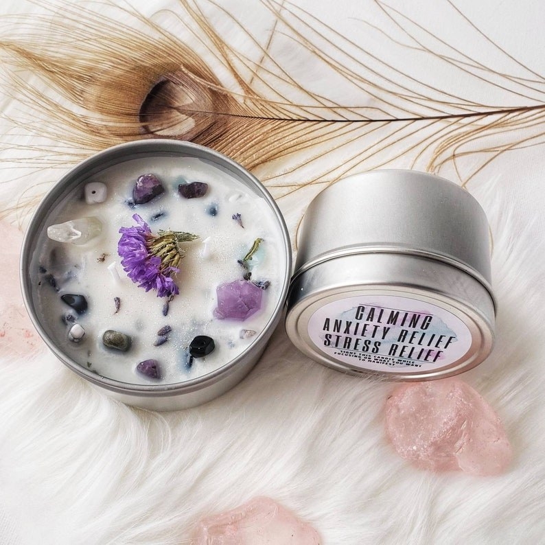 An anxiety relief candle topped with various crystals and lavender