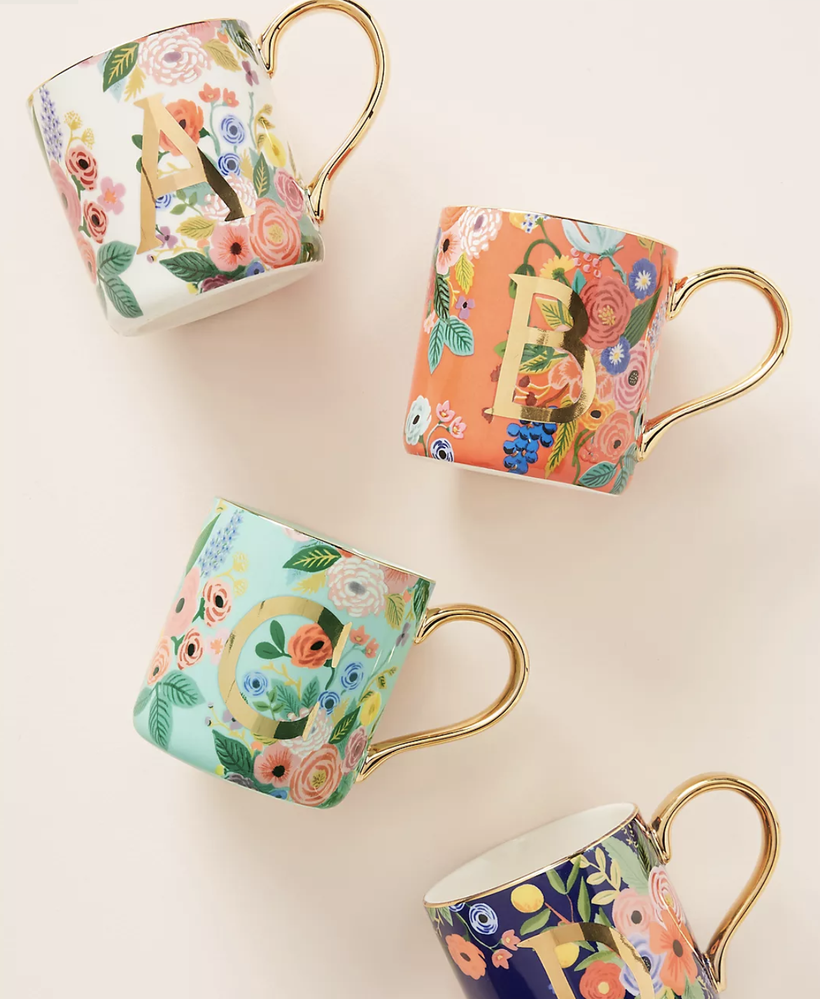 Mugs with monogrammed gold letters surrounded by garden themes with gold handles