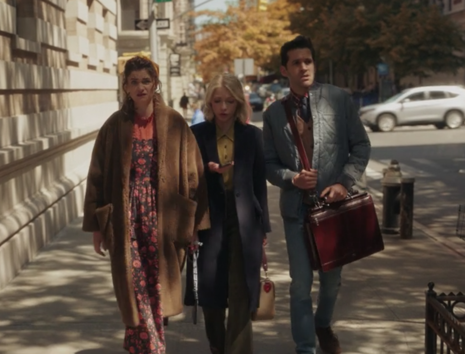 Wendy wears a floor length floral dress under a fur coat, Kate Keller wears a brightly colored blouse under a dark jacket with matching pants, and Jordan Glassberg wears a vest under a puffy jacket and jeans