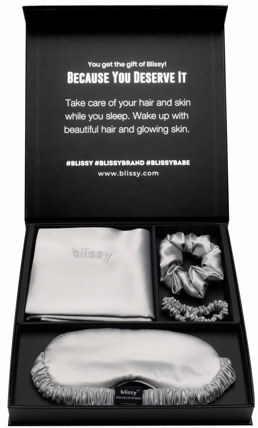 A gift box filled with silky sleepwear is shown