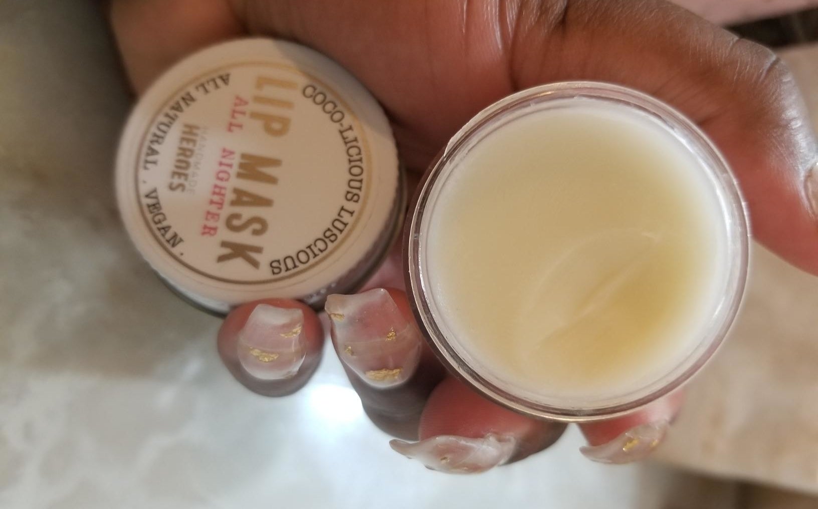 reviewer holding open jar of the overnight lip mask