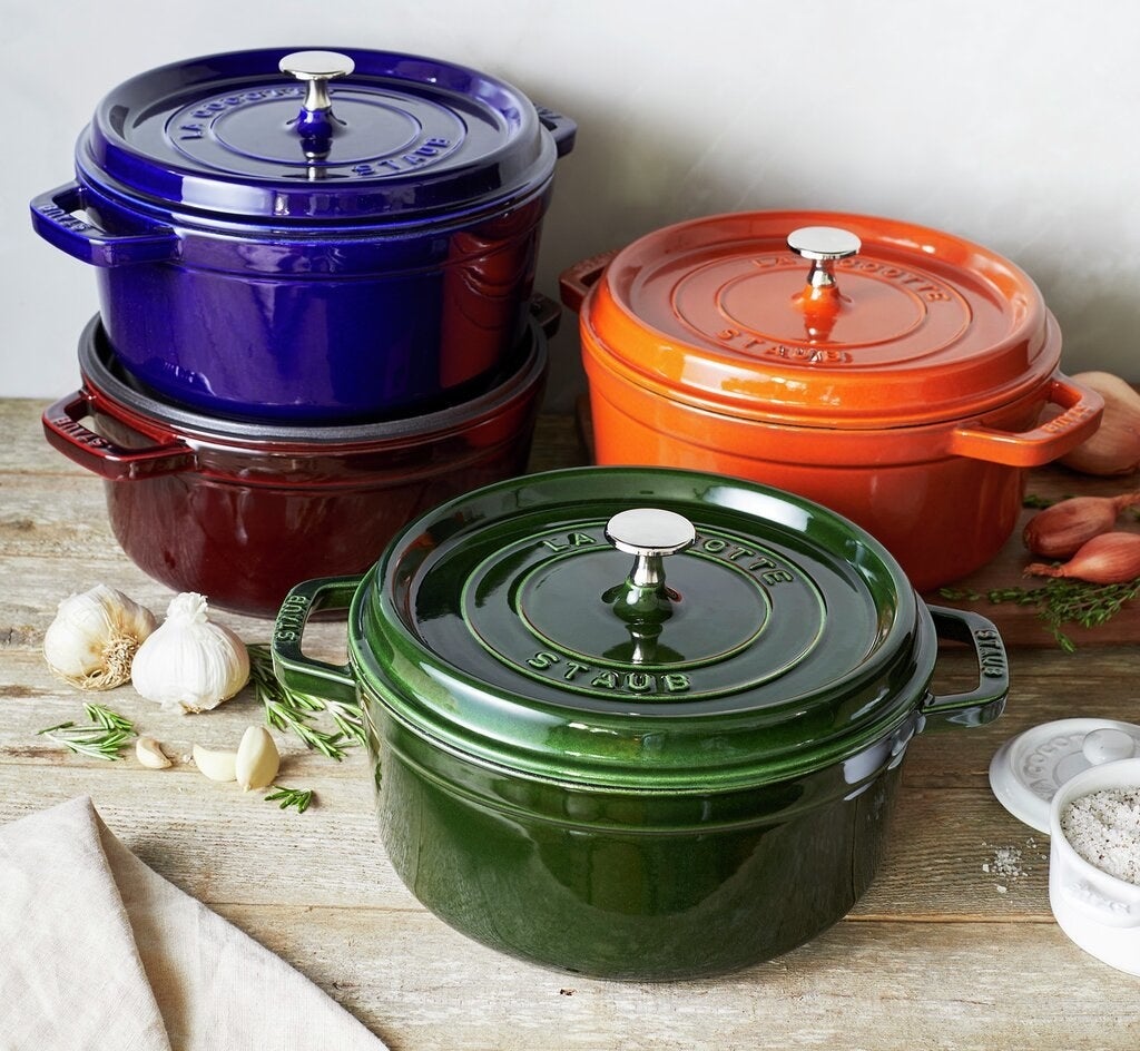 the Staub dishes displayed in green, burgundy, blue and orange