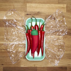 Red chili pepper vibrator on pile of actual chili peppers