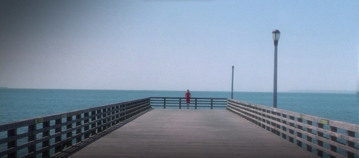 A woman in a red dress standing at a pier in &quot;Requiem for a Dream&quot;