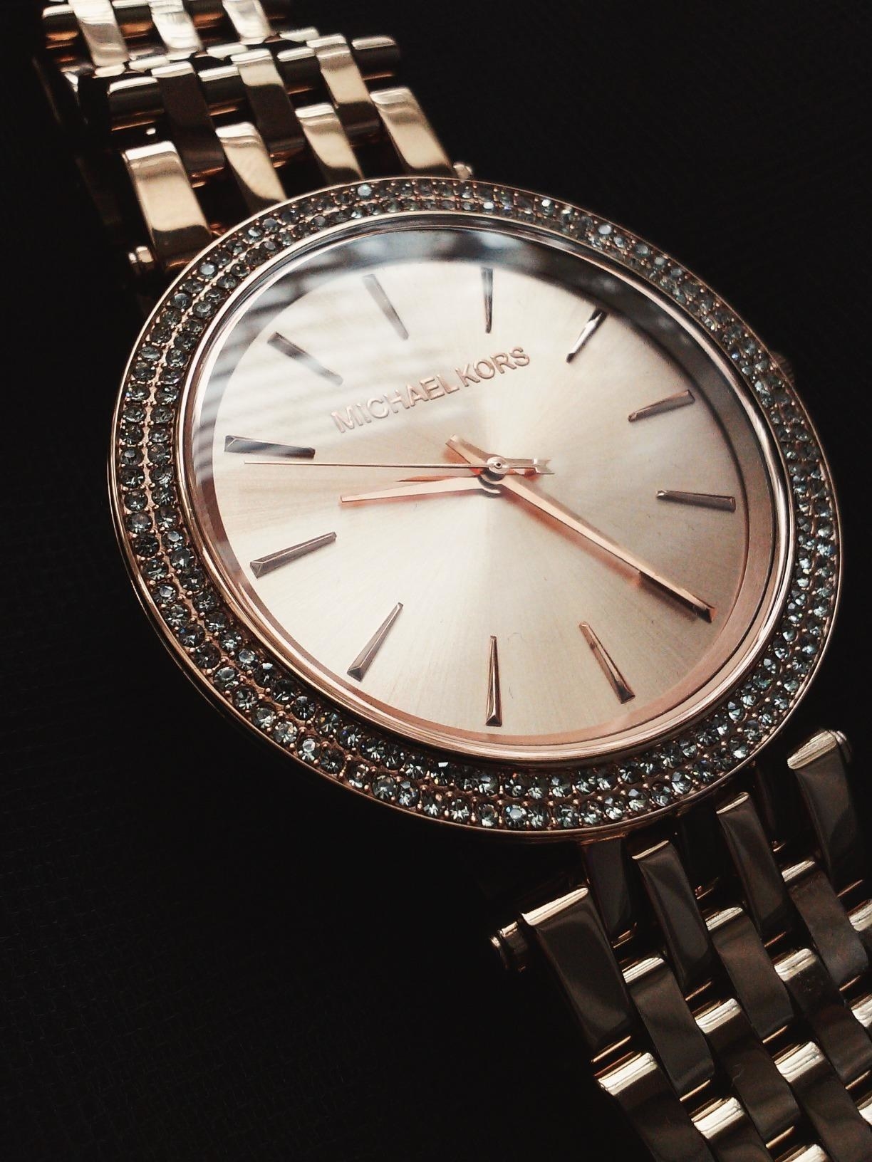 a reviewer&#x27;s close up on the watch with crystals around the face of it