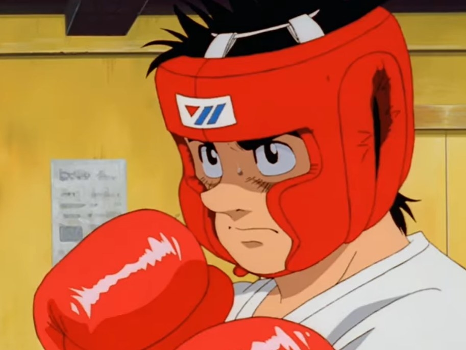 Ippo wearing boxing gloves and headgear ready to spar