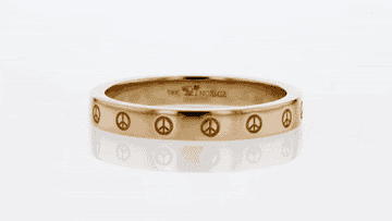 a gif of a gold band ring with peace signs around it