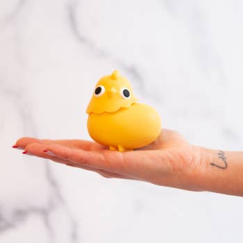 hand holding chick-shaped toy