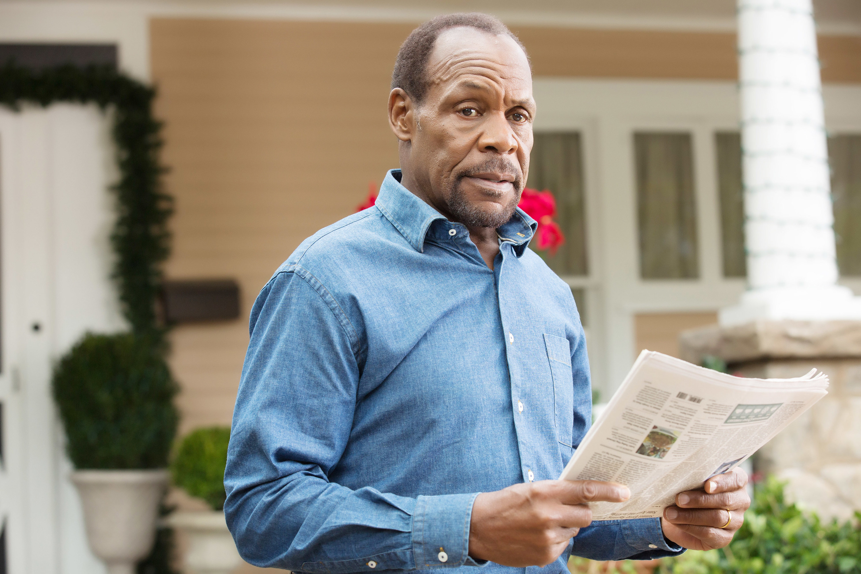 Danny Glover with a newspaper in Almost Christmas