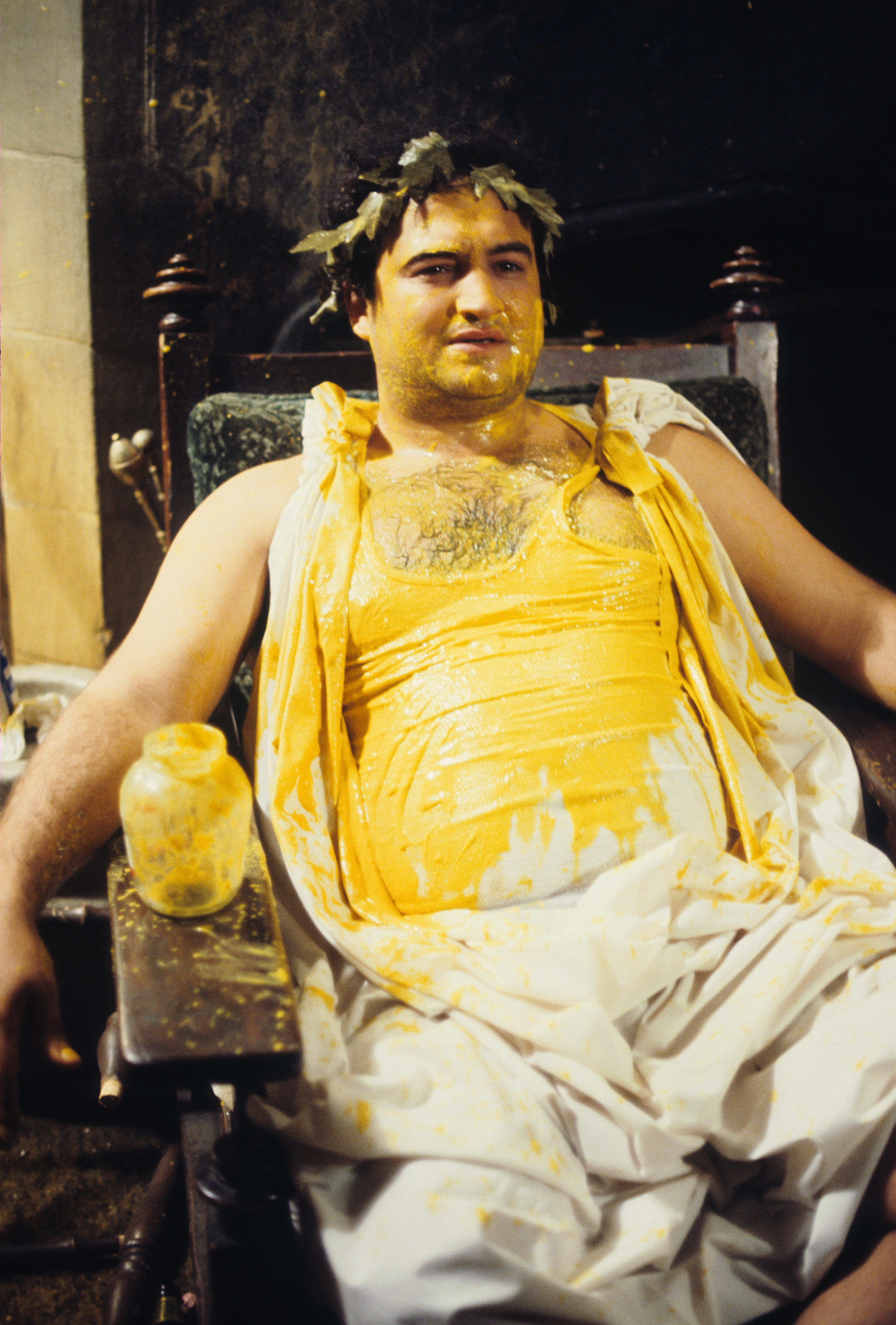 man in a toga covered in yellow liquid