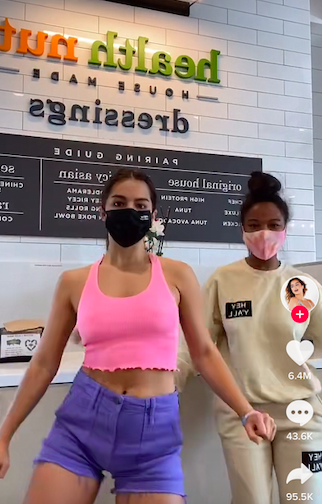 Addison Rae and Quen Blackwell doing a TikTok dance in a restaurant