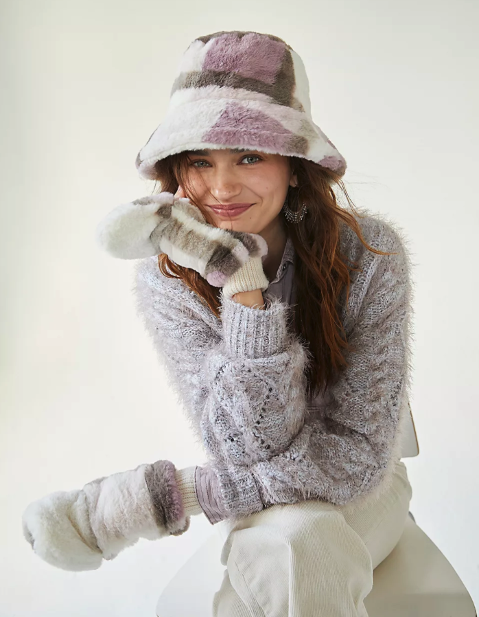 model wearing the purple, white and gray plush hat and mittens