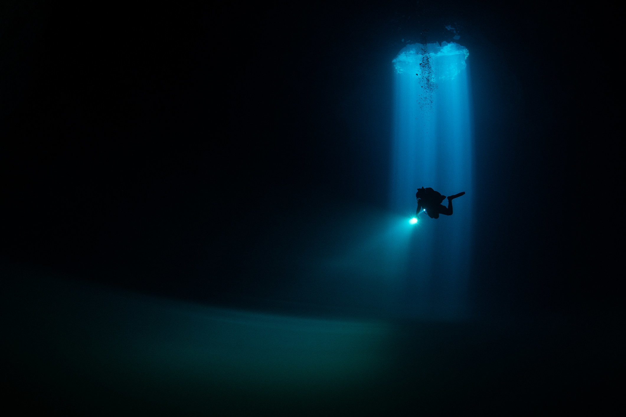 A lone diver highlighted underwater