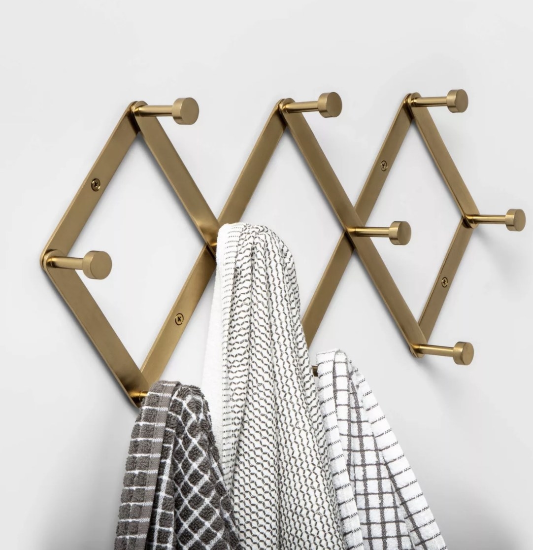 The brass hook rack has three diamond shaped frames and 10 round hooks