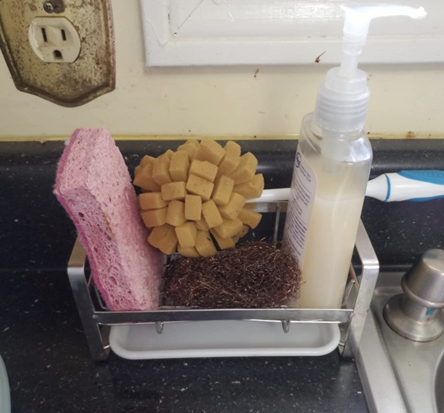 reviewer photo showing the caddy filled with sponges and soap next to their kitchen sink