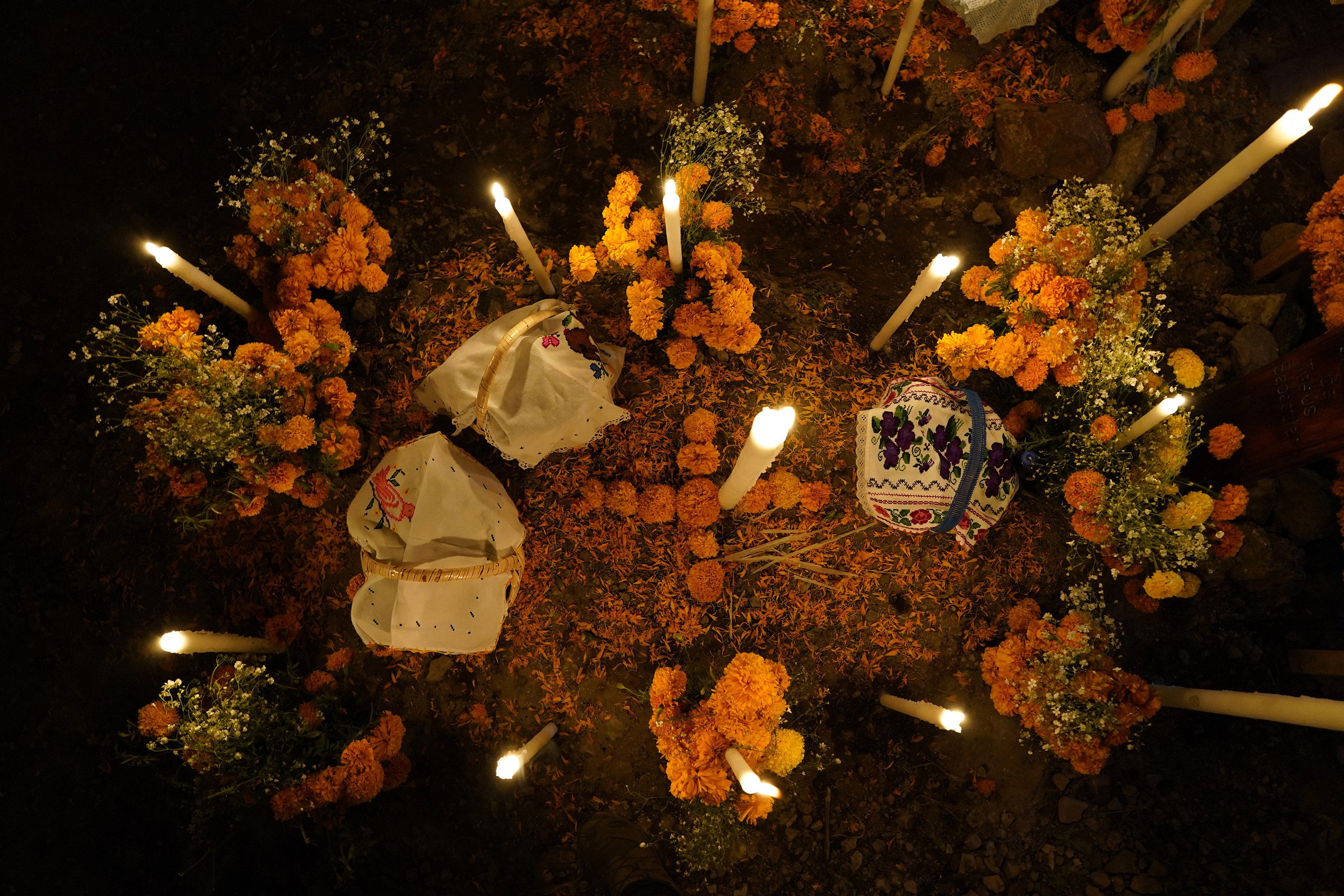 candles, baskets and flowers at a shrine for day of the dead 