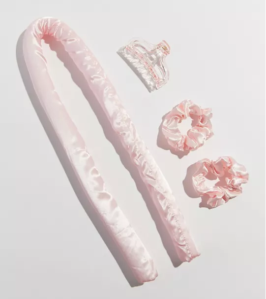 A long tube next to a hair clip and two scrunchies