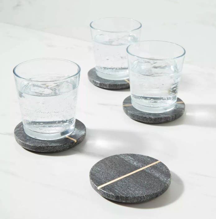 Three coasters with glasses of sparkling water and one coaster with nothing on it