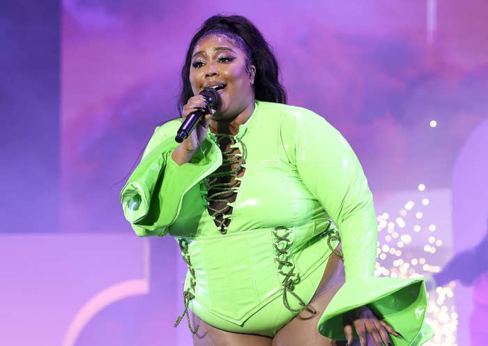 Lizzo singing onstage in a lace-up leotard