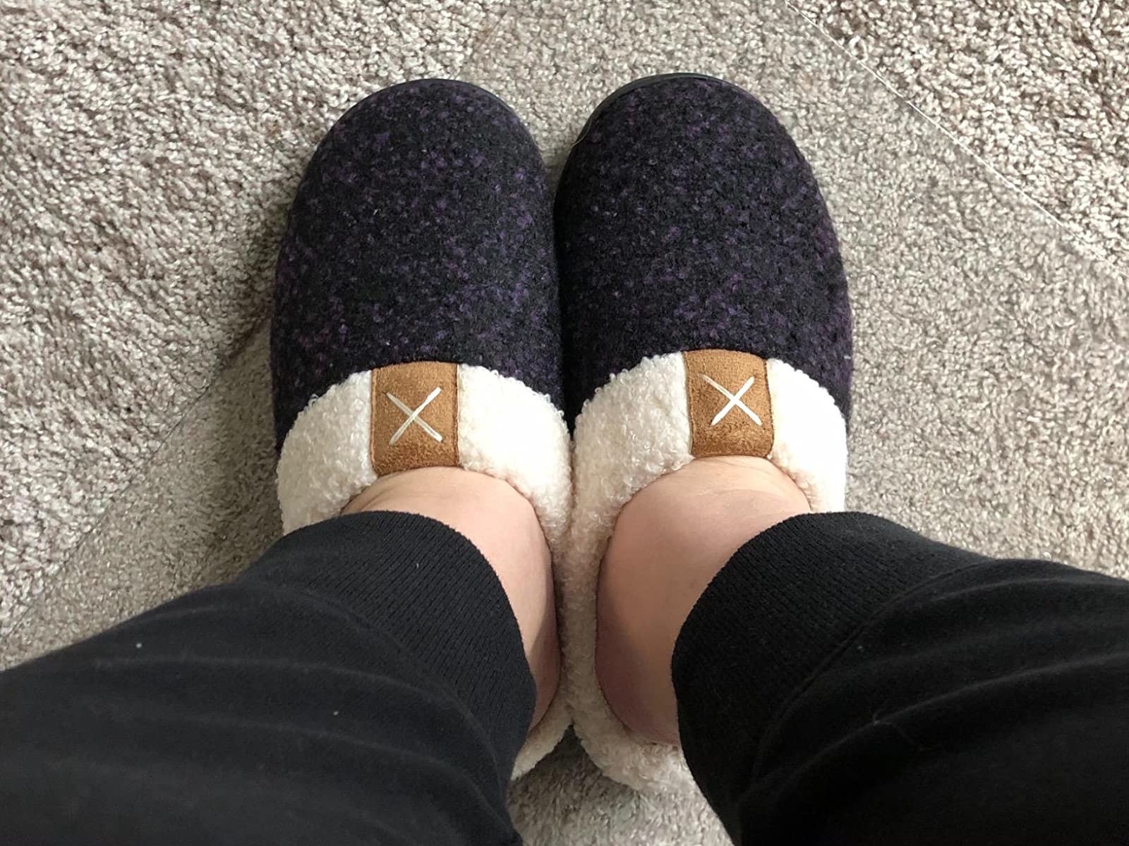 reviewer wearing the slippers in black with white insides