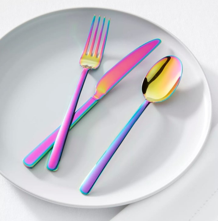 A rainbow fork, knife, and spoon from the set on a plate